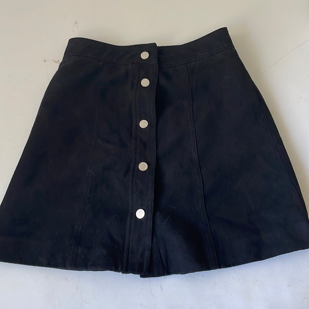 This is a black tight mini skirt from H&M, 5 Metal buttons, 100% polyester